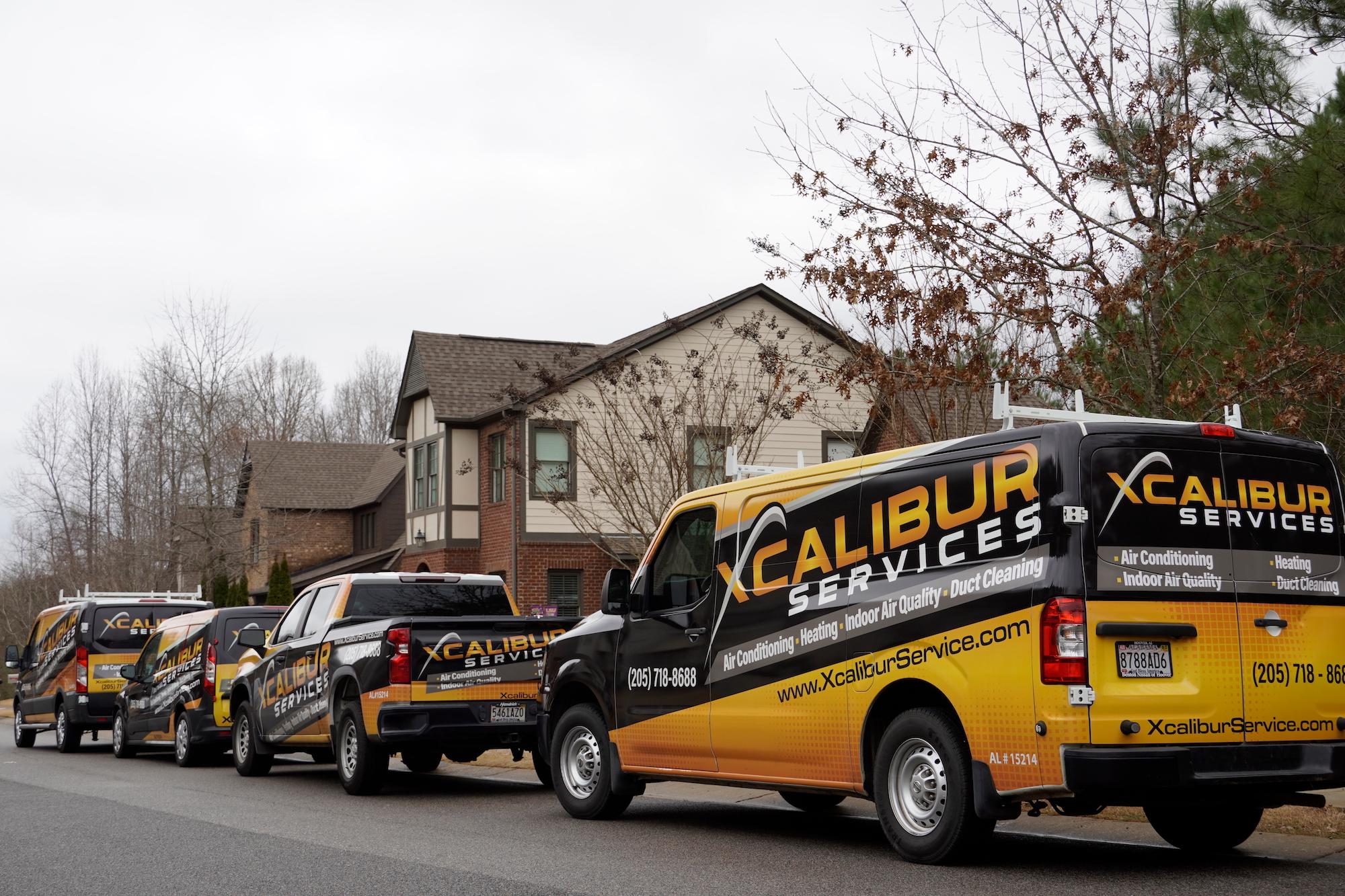 Xcalibur work trucks and vans in front of house to perform heating repairs in Pelham, AL